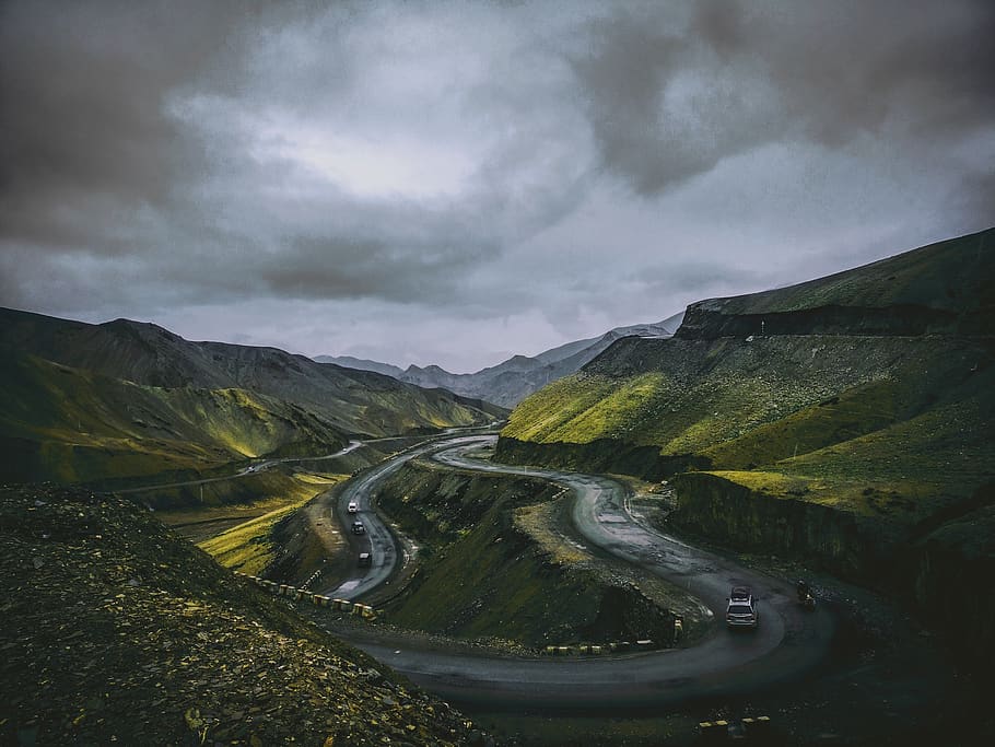 Cars Travelling on Concrete Winding Road Under Grey Cloudy Sky HD wallpaper