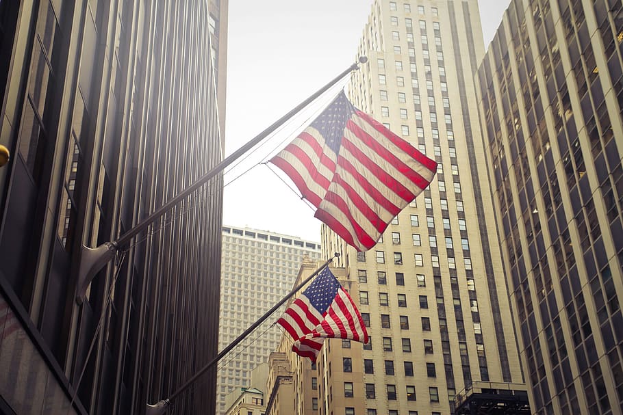 American flags waving in the city on a sunny day with skyscrapers in the background, HD wallpaper