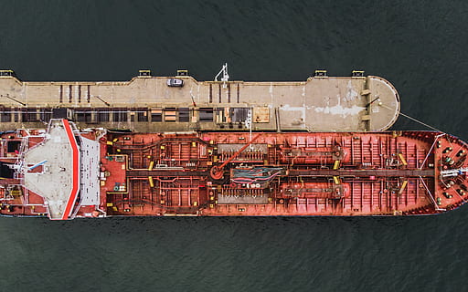 Aerial view of forward part of the hull of a ship docked at the port surrounded with sea water HD wallpaper