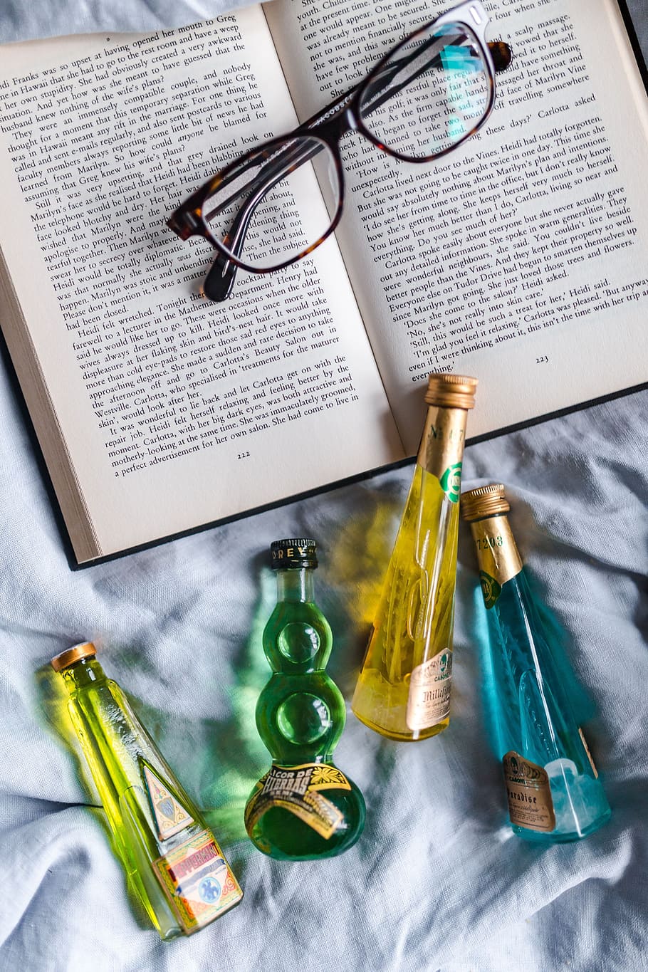 Group of colorful little bottles with liqueurs, book, drink, read