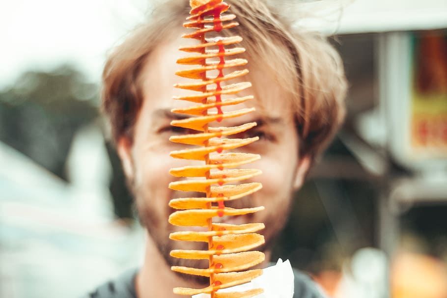 smiling man behind piled chips during daytime, one person, focus on foreground HD wallpaper