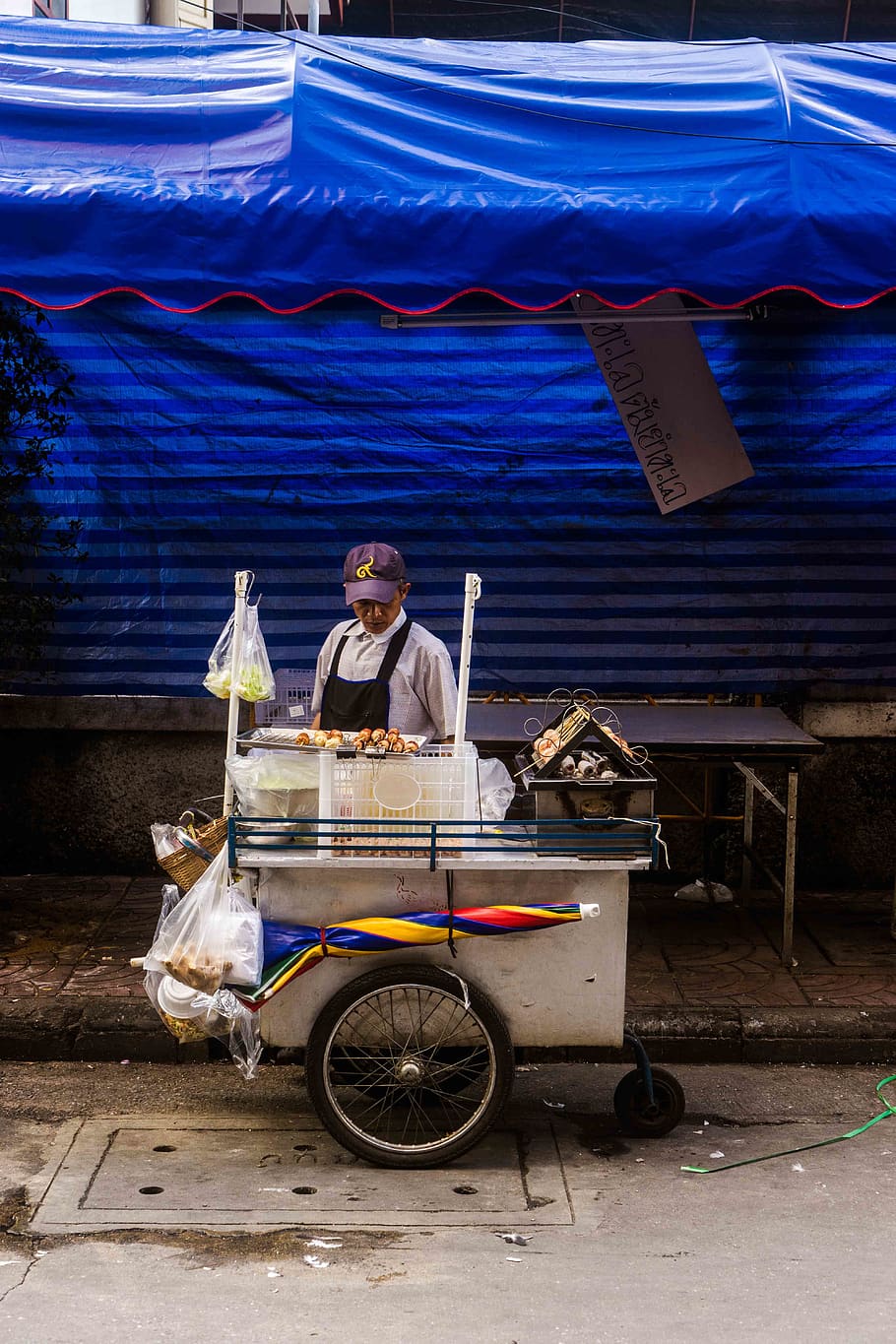 man standing in front of ice cream stall, wheel, machine, person