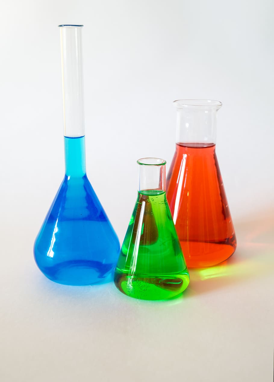 three assorted-color liquid-filled laboratory apparatuses, glare