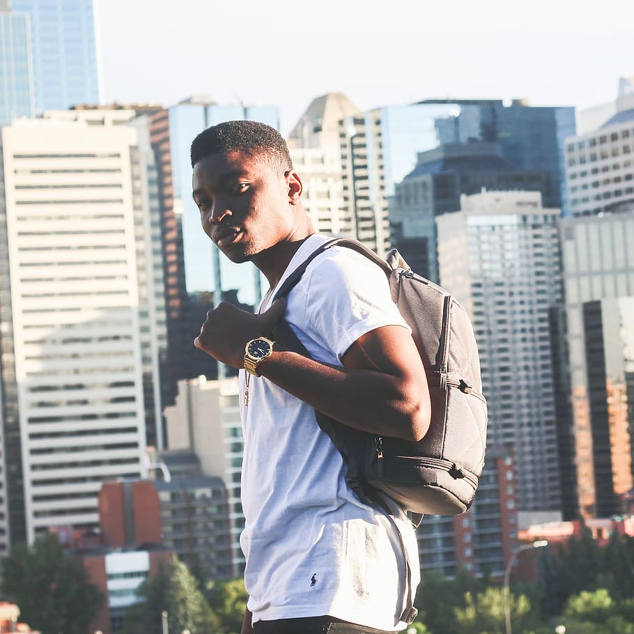 man carrying gray backpack standing, person, human, people, building HD wallpaper