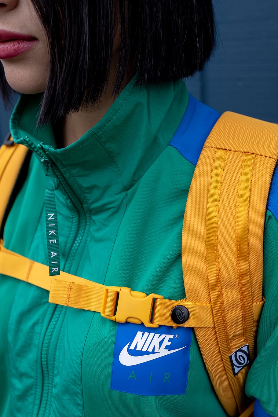 Woman Wearing Green Nike Zip Top and Yellow Backpack, adult, brand trademark