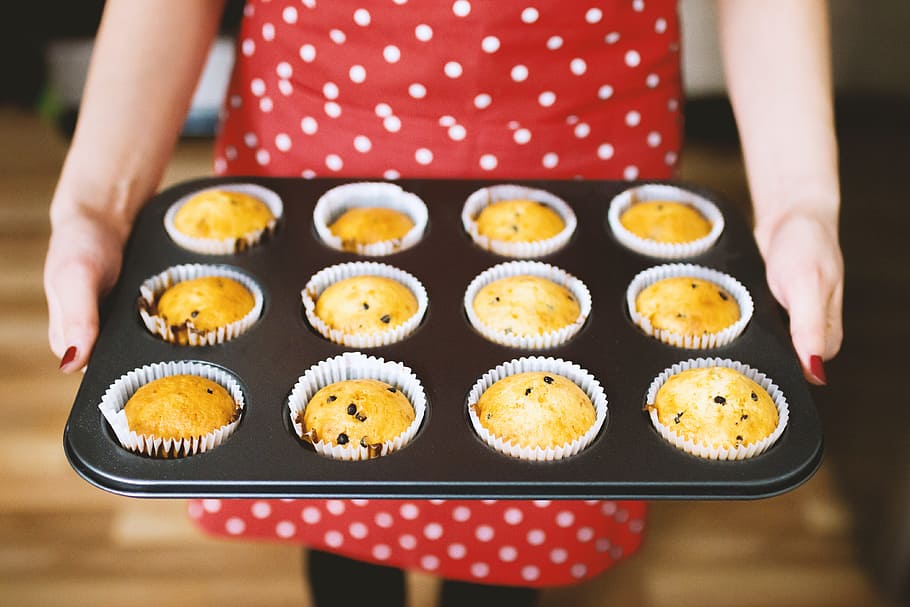 A young lady in a beautiful red apron just baked muffins, one person HD wallpaper