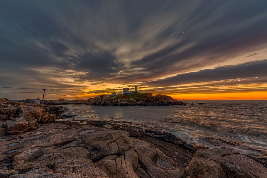 rocky shore under cloudy sky, water, cloud - sky, sunset, built structure HD wallpaper