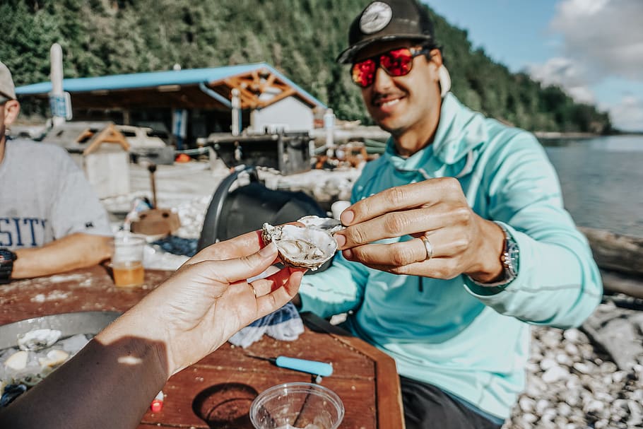 raw oyster, real people, smiling, holding, human hand, young men HD wallpaper