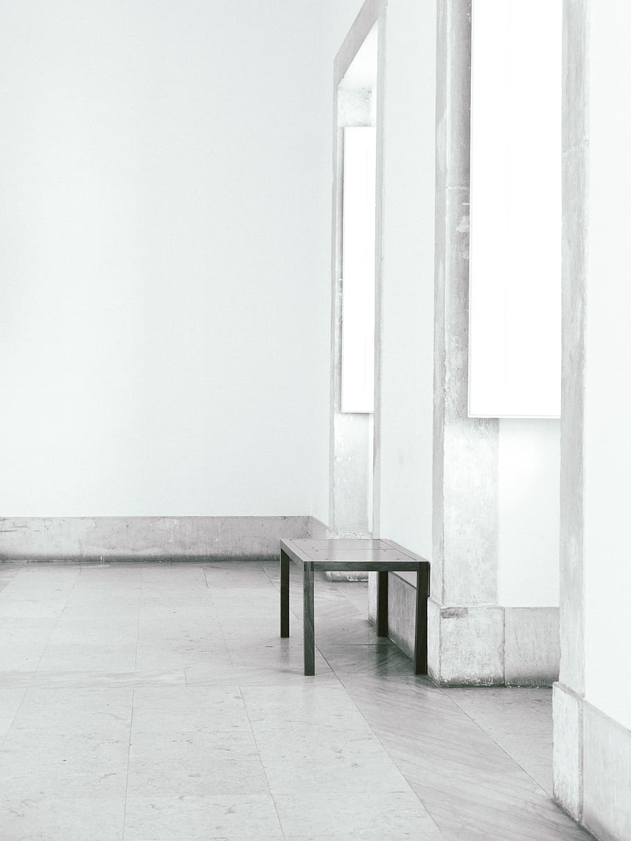 end table beside wall near doorways, absence, seat, indoors, empty