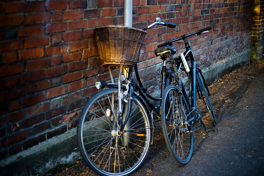 Two Black Bikes Parked Upright Beside Red Bricked Building, basket HD wallpaper