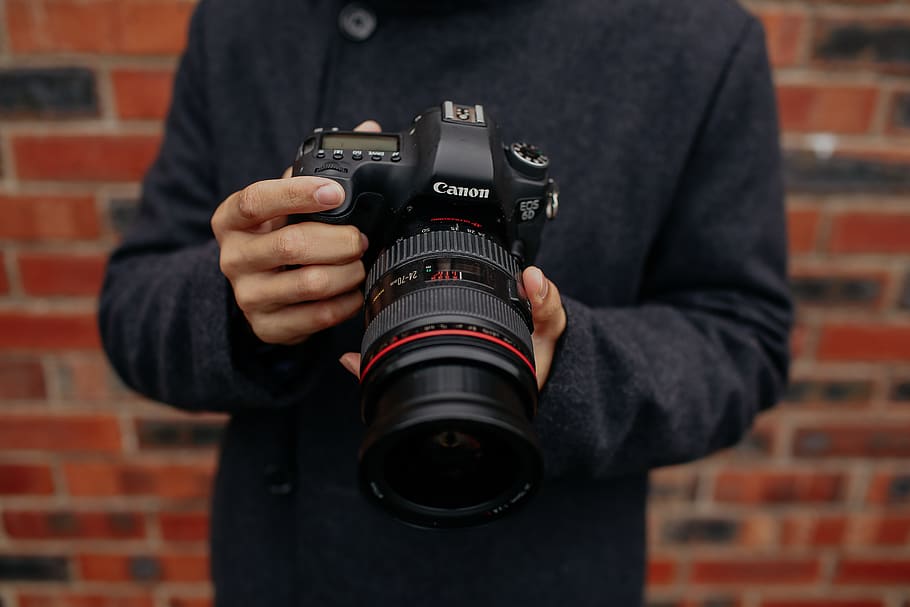 shallow focus photo of person holding black Canon DSLR camera, HD wallpaper