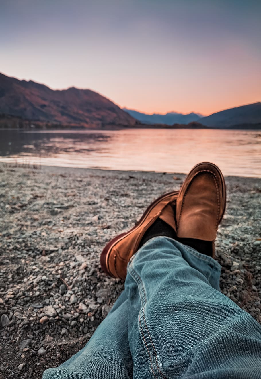 Person Wearing Blue Jeans and Brown Leather Loafers Sitting Beside Gray Sand, HD wallpaper