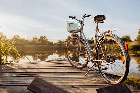 Bicycle with basket on the pier in bright sunset light, evening HD wallpaper