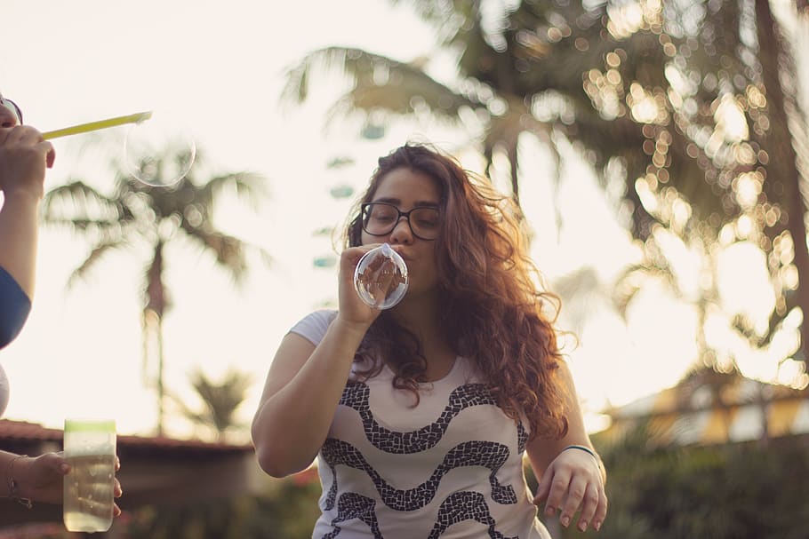 Photo of Woman Blowing Bubbles, blur, curly hair, depth of field HD wallpaper