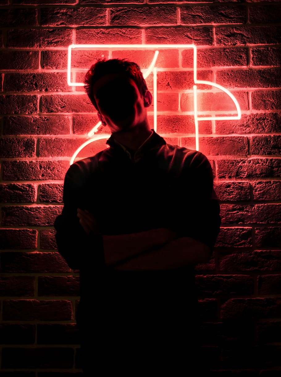 man standing near red lighted wall, one person, brick, brick wall HD wallpaper