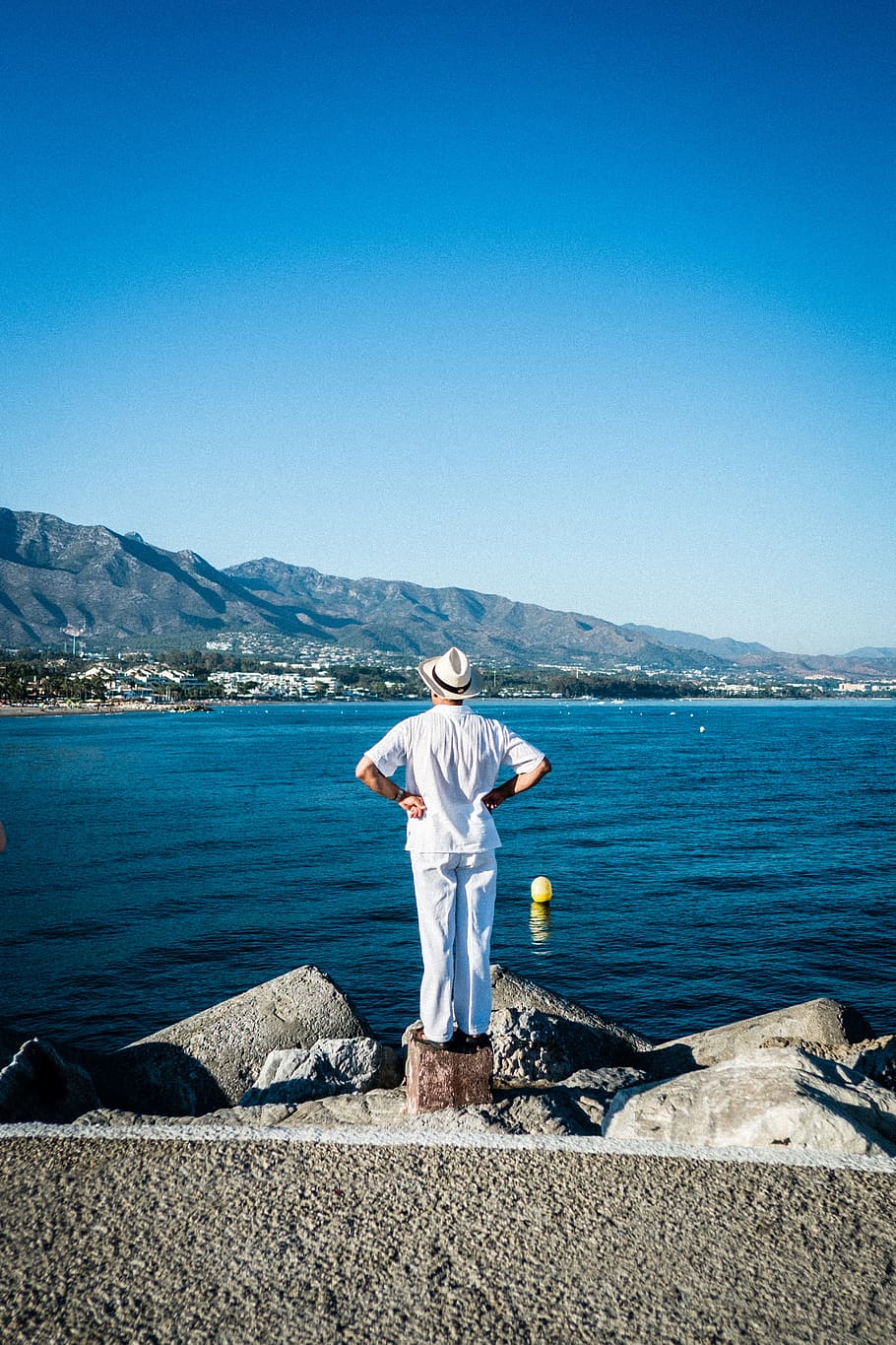 person in white top looking at the sea, man, rock, stone, view HD wallpaper