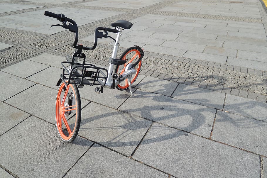 grey and orange folding bike on grey tile, tricycle, transportation