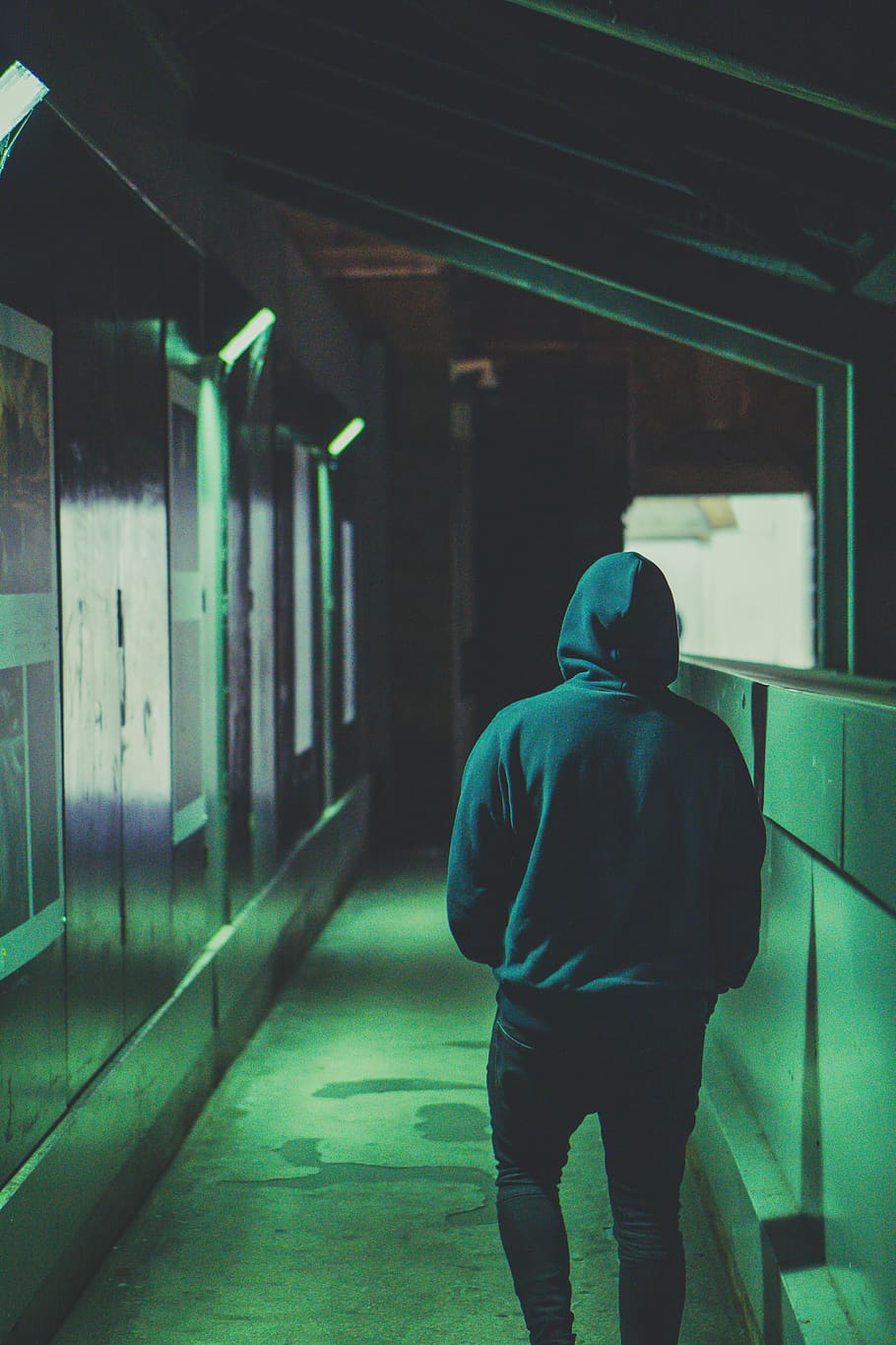 man wearing hoodie walking near wall, apparel, clothing, human