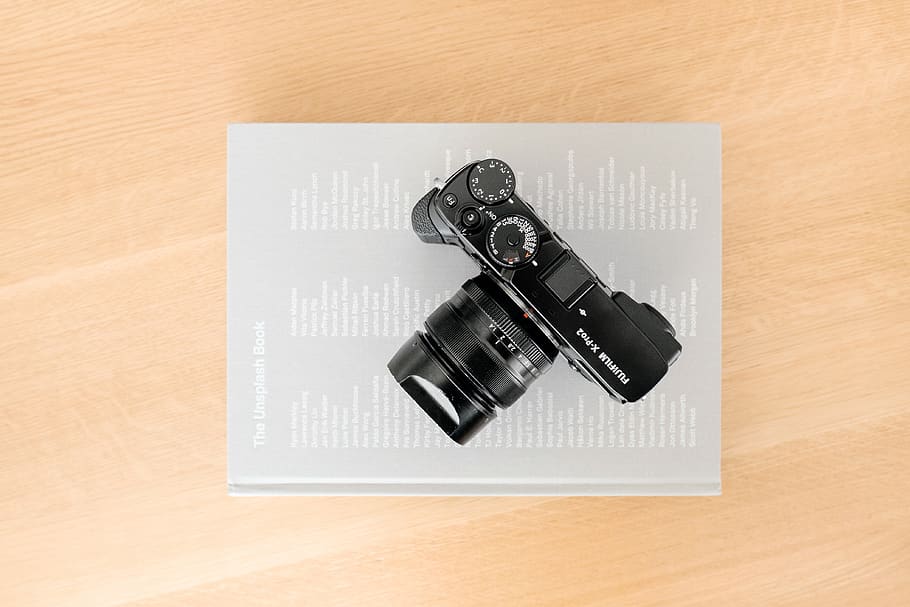 black DSLR camera on gray book, high angle view, table, indoors HD wallpaper