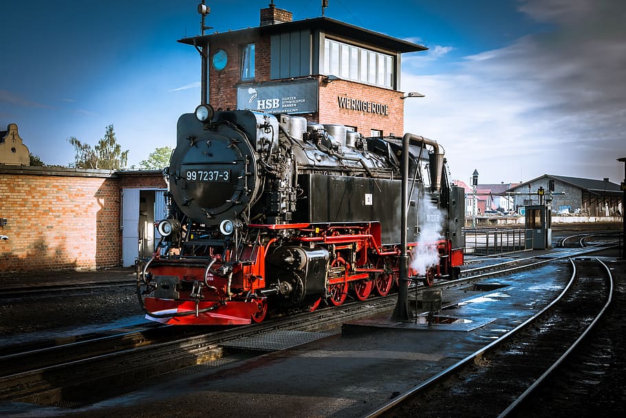 Train on Railroad Tracks Against Sky, blur, city, clouds, downtown HD wallpaper