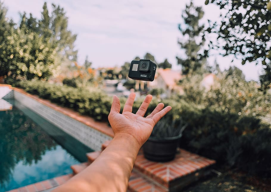 person throwing black action camera, human, finger, los angeles HD wallpaper