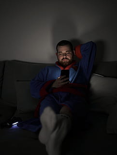 man sits on sofa while using smartphone, couch, furniture, human HD wallpaper