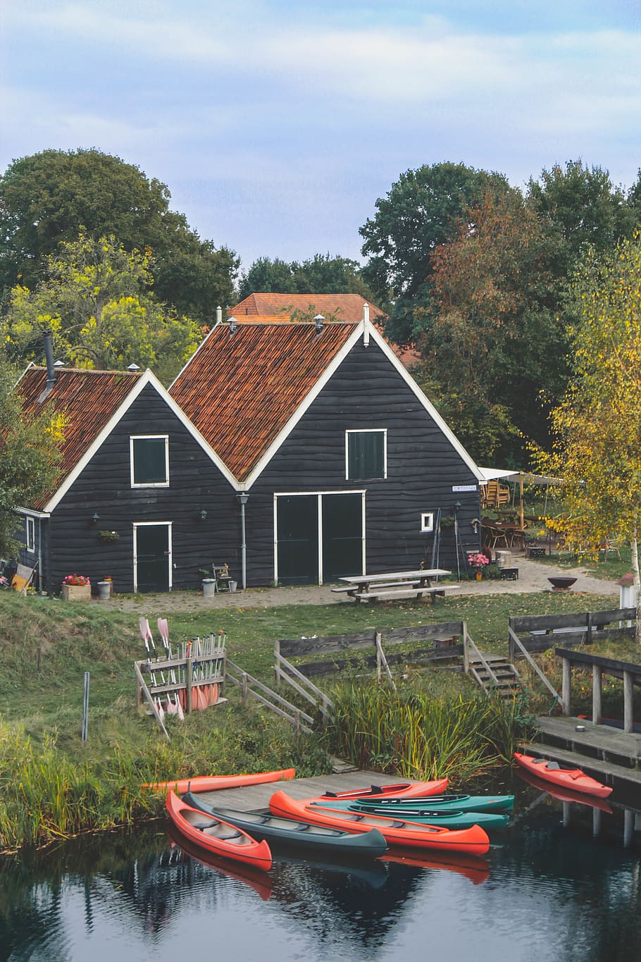 black and brown house near boats on river, bench, roof, vessel
