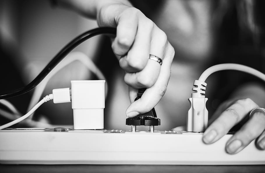 Person Holding Black Cable Wire and Power Strip, black and white