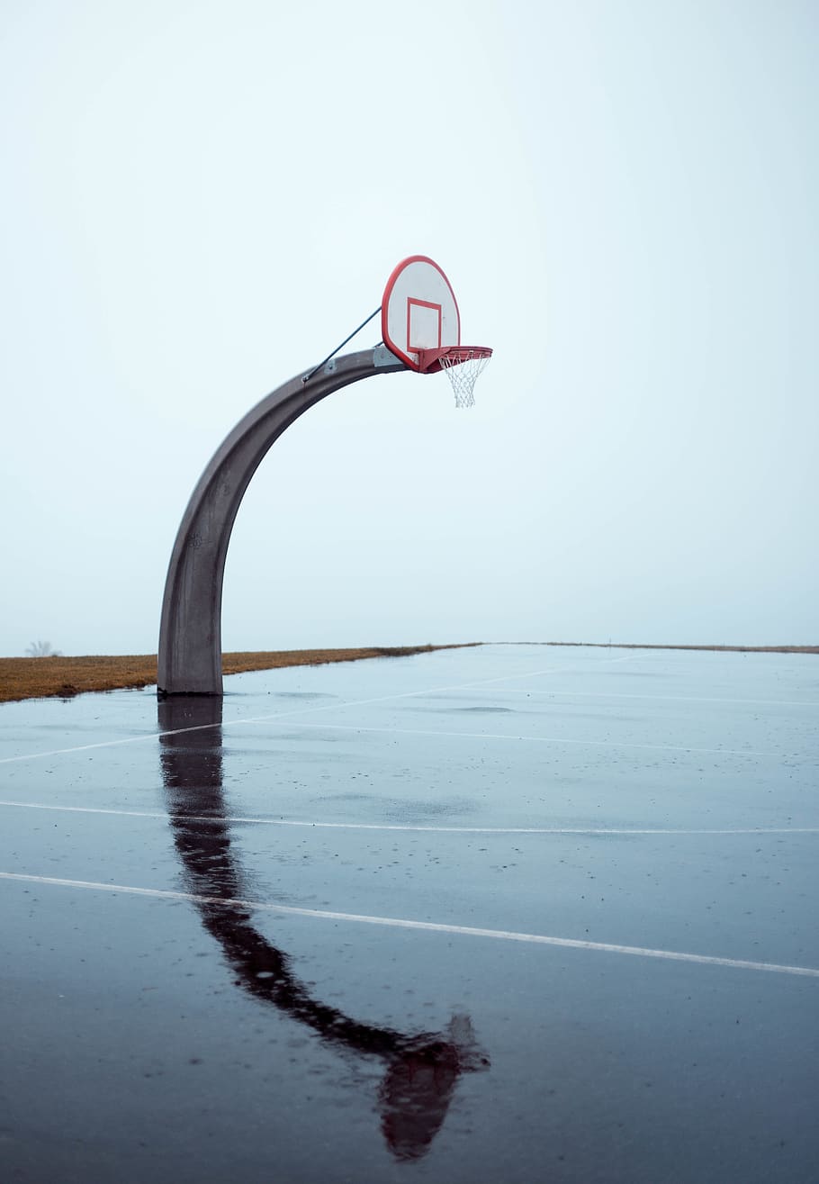 Photo of Empty Concrete Basketball Court on Gloomy Day, basketball basket