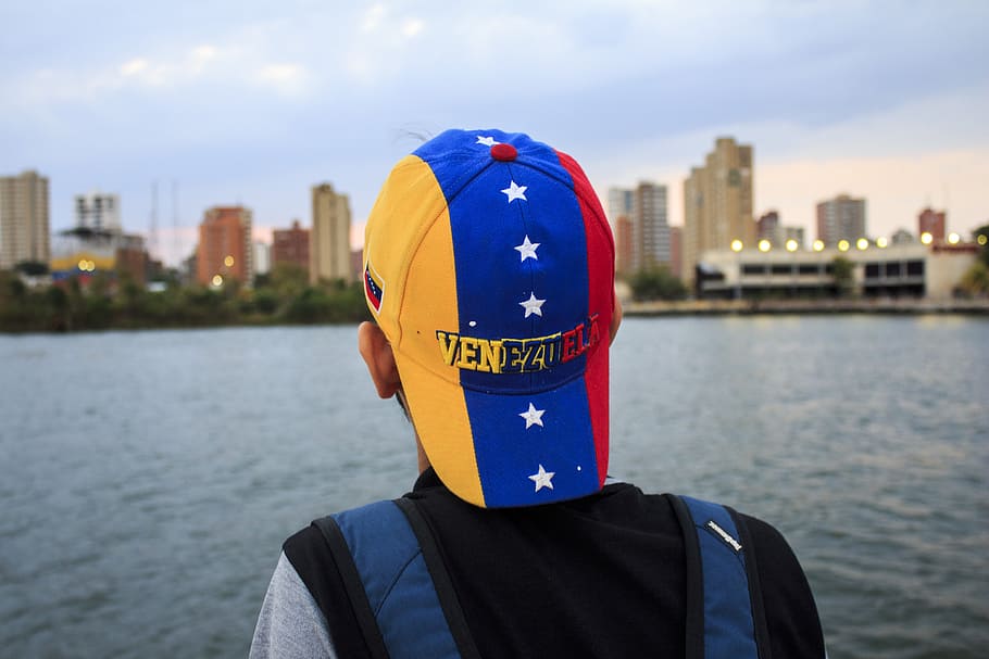 Person Wearing Black and Gray Shirt With Yellow, Blue, and Red Star Print Cap HD wallpaper