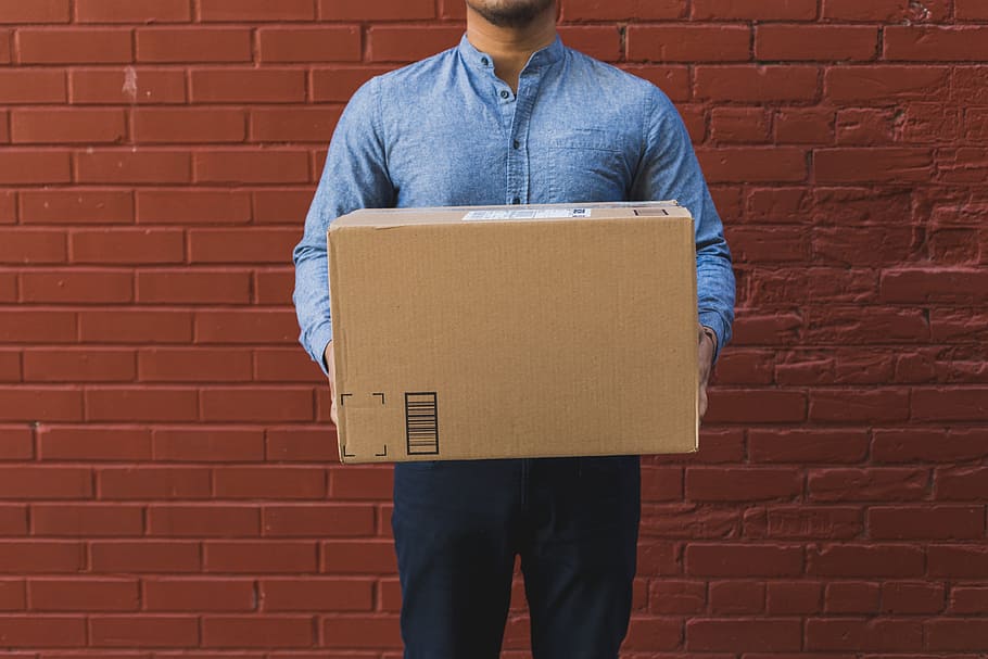 Man Holding Shipping Box On Red Brick Photo, Business, Products