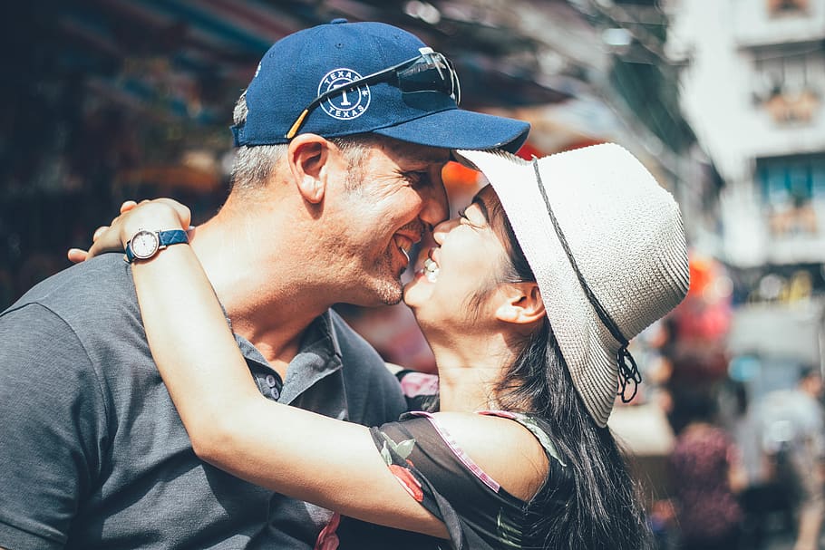 Man and Woman Kissing on Street, blurred background, cap, daytime HD wallpaper