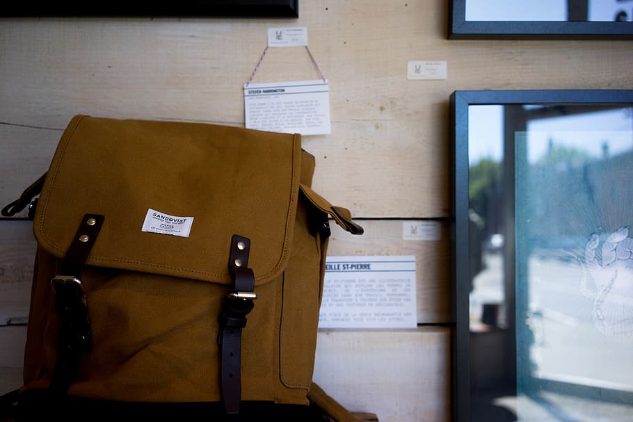brown knapsack beside flat screen TV, indoors, paper, document HD wallpaper