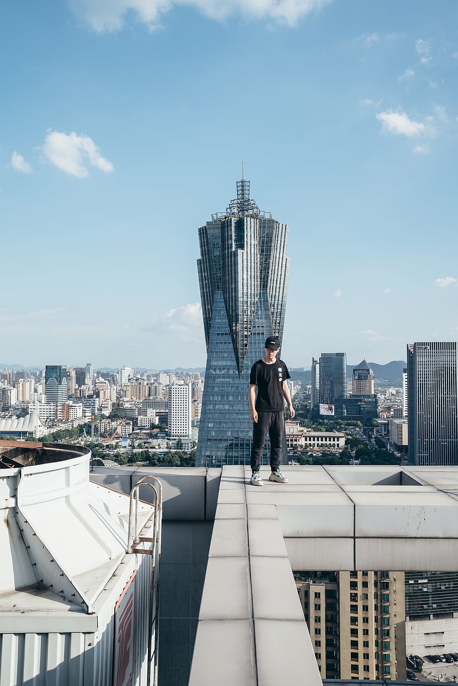 man standing on top of a building, city, person, roof, edge, cloud