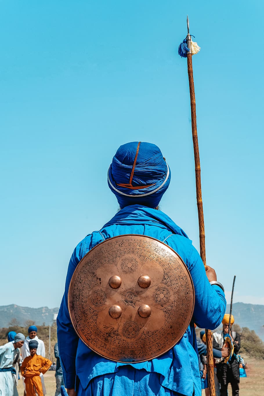 man standing while holding brown stick, blue, clear sky, human representation HD wallpaper
