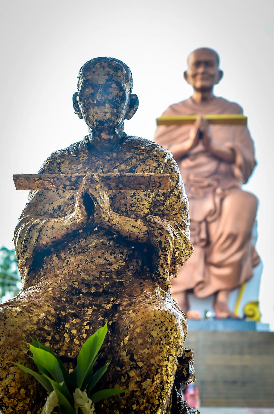 Thai monk in Ayudhaya, Thailand - contrasting statues., buddhism