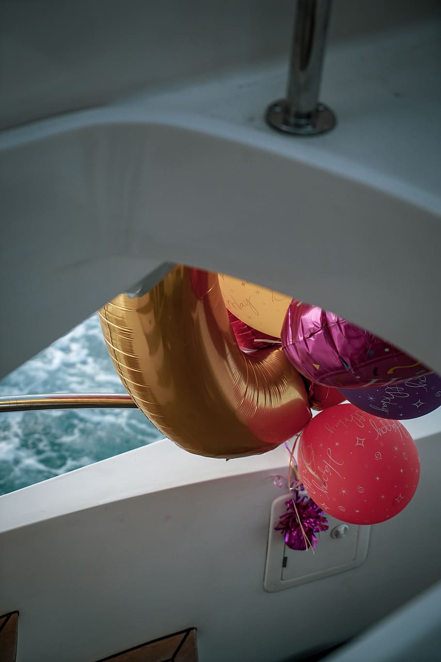 assorted-colored mylar balloons, water, high angle view, focus on foreground HD wallpaper