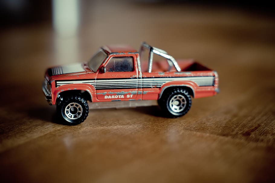 Red and Gray Single Cab Pickup Truck Scale Model on Table, blur