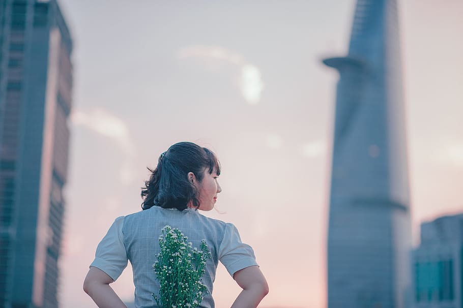 photo of Woman in Gray Top Holding Flowers on Her Back, beautiful HD wallpaper