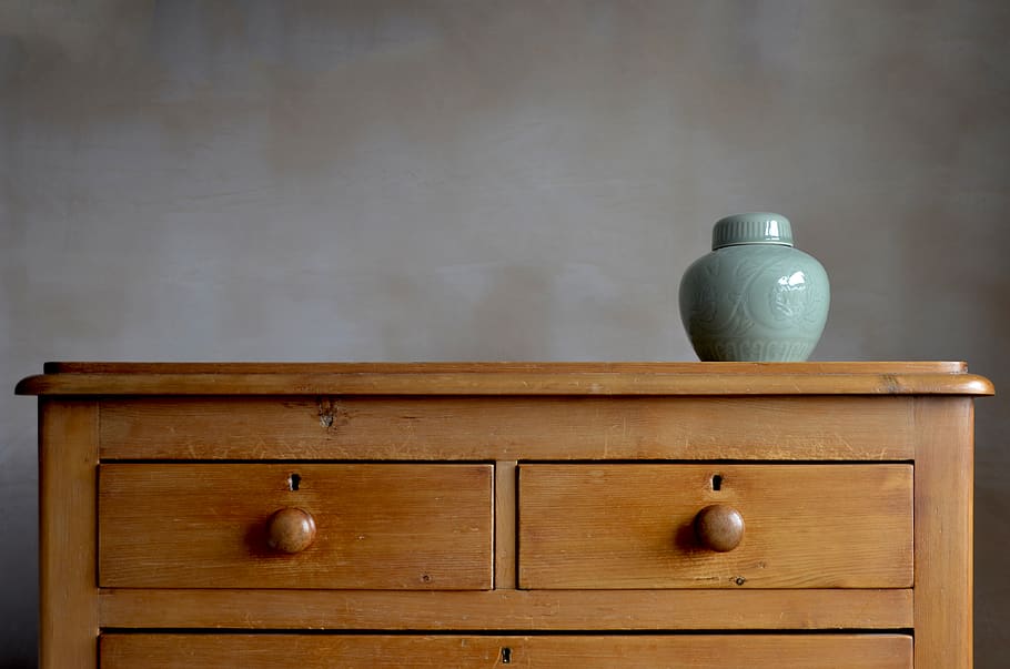 blue-ceramic-vase-on-brown-wooden-darawer-dresser.jpg