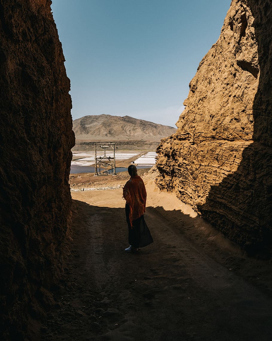 monk standing between cliff, lamdscape, portrait, teal, orange HD wallpaper