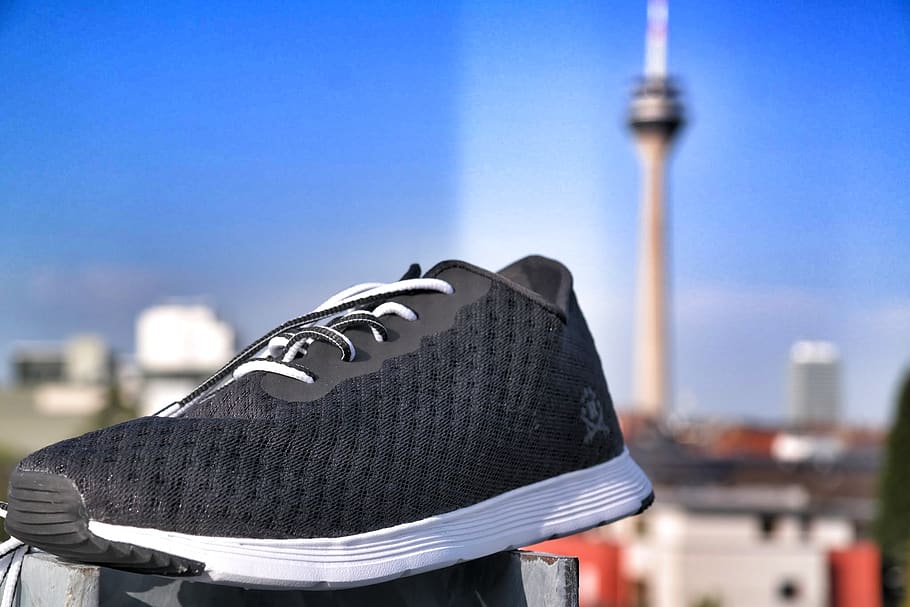 Unpaired of Black and White Lace-up Sneaker in Selective Focus Photography