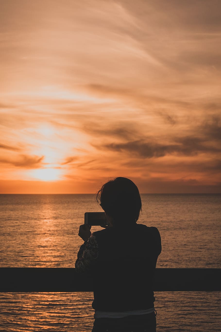 Person Holding Smartphone Beside Body Of Water, backlit, dawn HD wallpaper