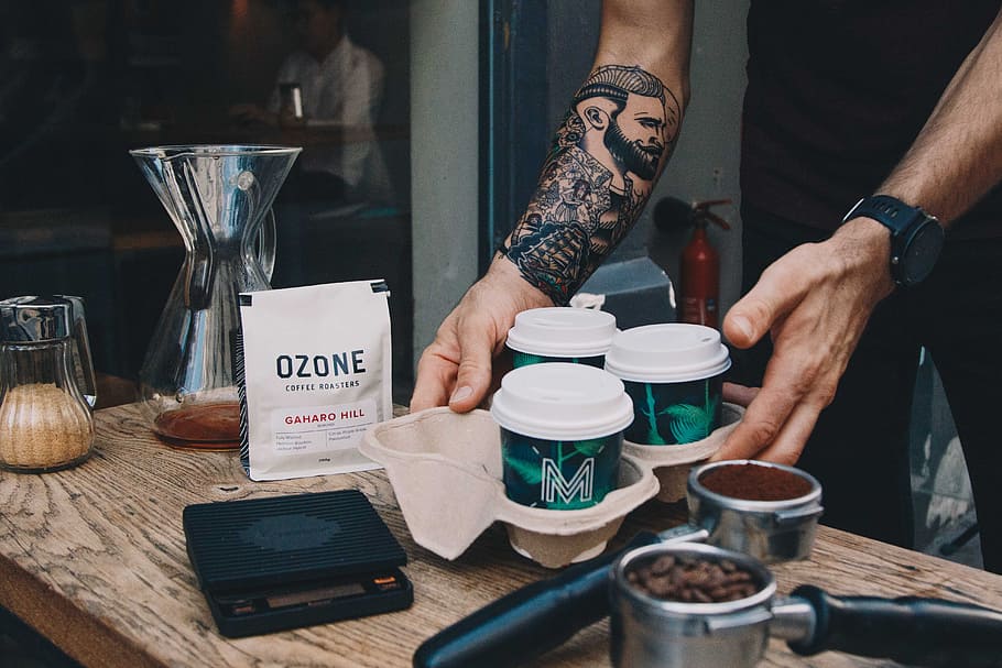 person holding white coffee cups, tattoo, chemex, ozone, takeaway