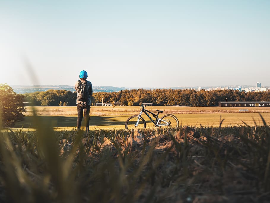 man standing on grass field, bike, mountain bike, vehicle, bicycle HD wallpaper