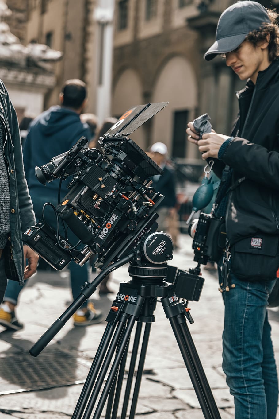 man standing beside professional camera, focus on foreground HD wallpaper