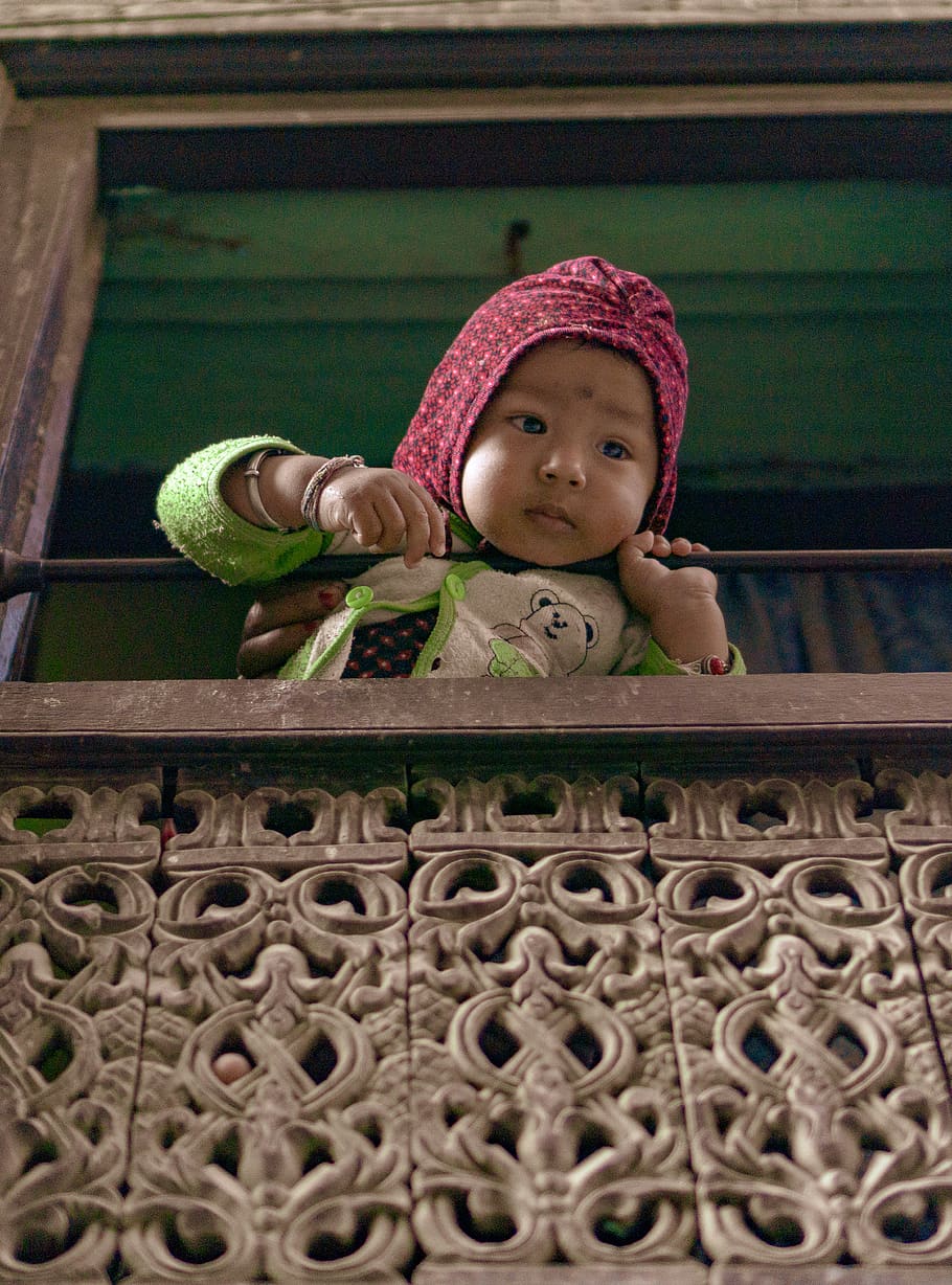 toddler-holding-on-brown-metal-rail.jpg