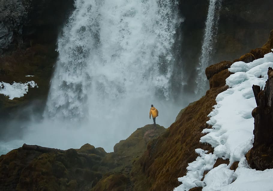 person hiking on brown mountain near waterfalls, raincoat, man HD wallpaper