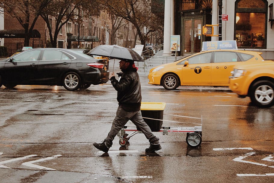 man using umbrella walking along wet road, person, human, transportation