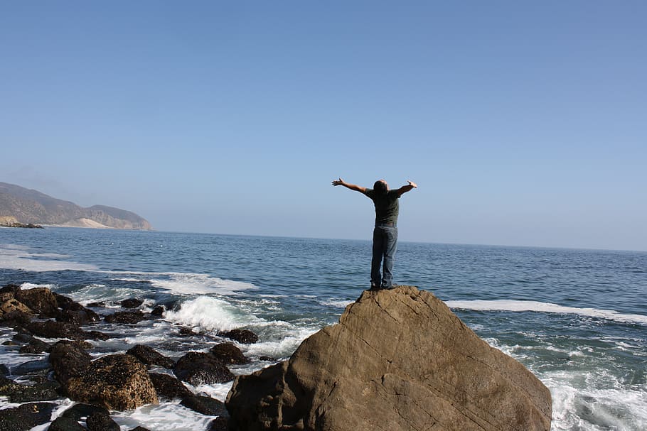 sea, human arm, water, sky, rock, rock - object, standing, real people HD wallpaper